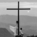 Man and Woman Pose On a Cross Monument